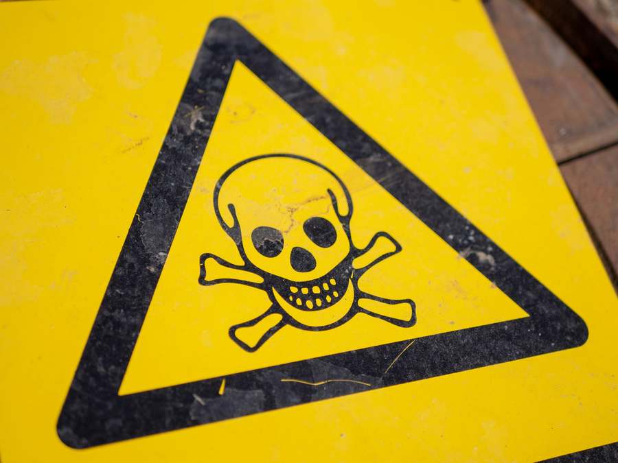 A yellow warning sign showing a skull and crossbones — the international symbol for a poisonous substance